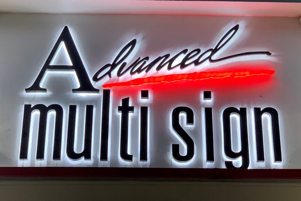 Advanced Multi Sign logo in reverse channel letters with a red side-lit accent