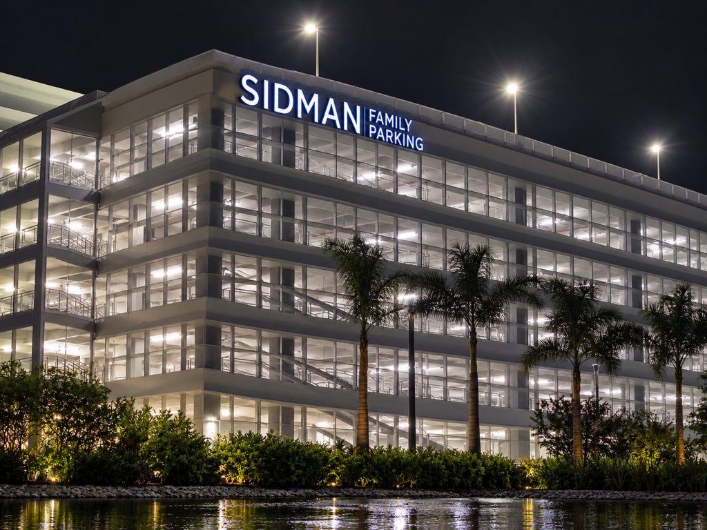 Sidman Family Parking garage with illuminated channel letters at night