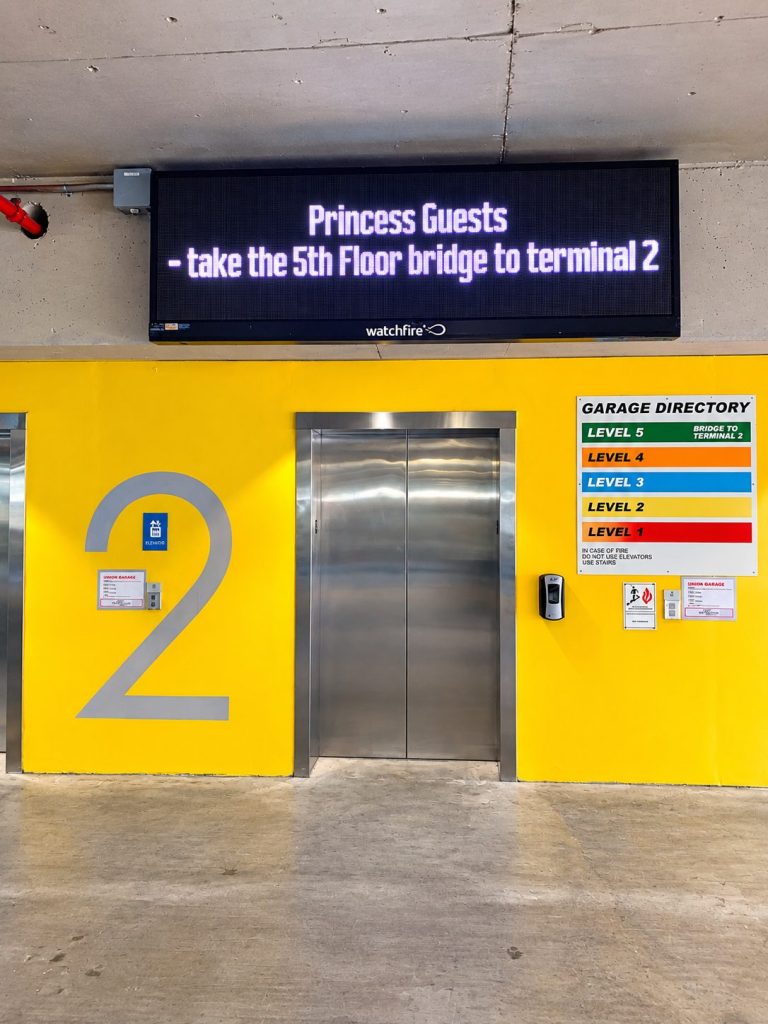 Electronic message center above a yellow garage elevator lobby
