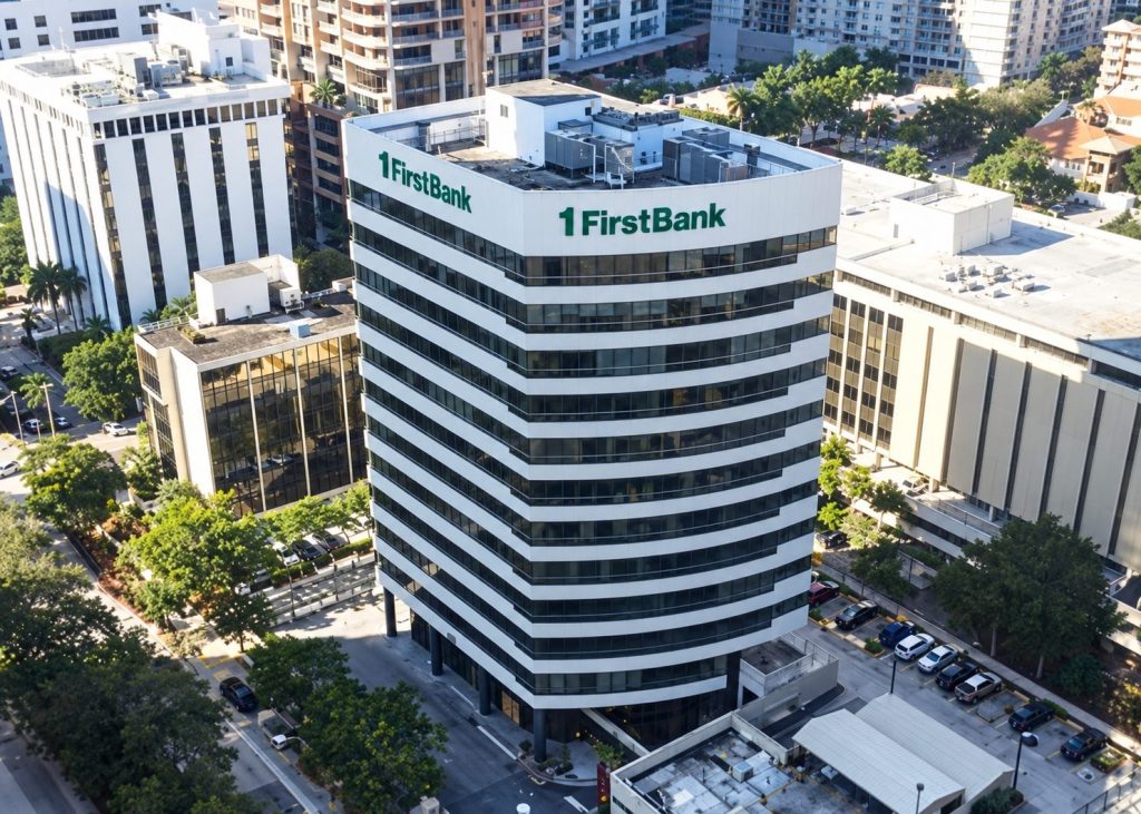 Aerial view of the 1FirstBank tower with rooftop signs