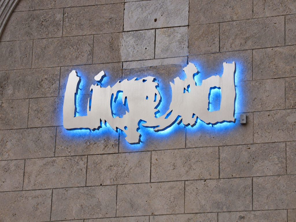 Illuminated reverse channel letters on a stone wall